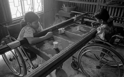 Två fysiskt handikappade tjejer sysslar med broderi på kläderna på The Center for the Rehabilitation of the Paralysed, CRP i Savar, Dhaka, Bangladesh. 2005.